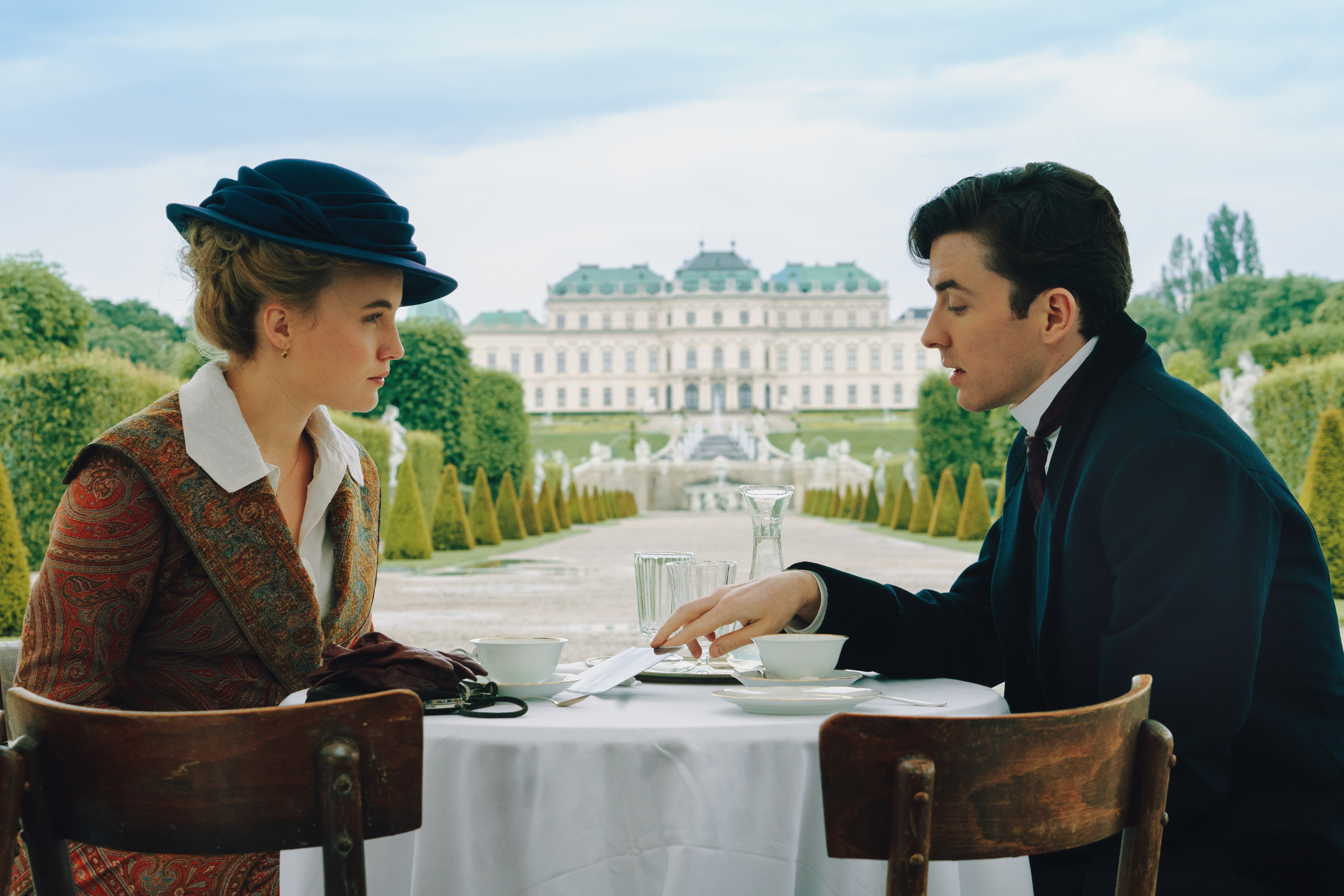 Picture shows: Luise von Finckh and Matthew Beard as Clara and Max, drinking tea in Belevedere Palace Gardens in 'Vienna Blood' Season 3. . 