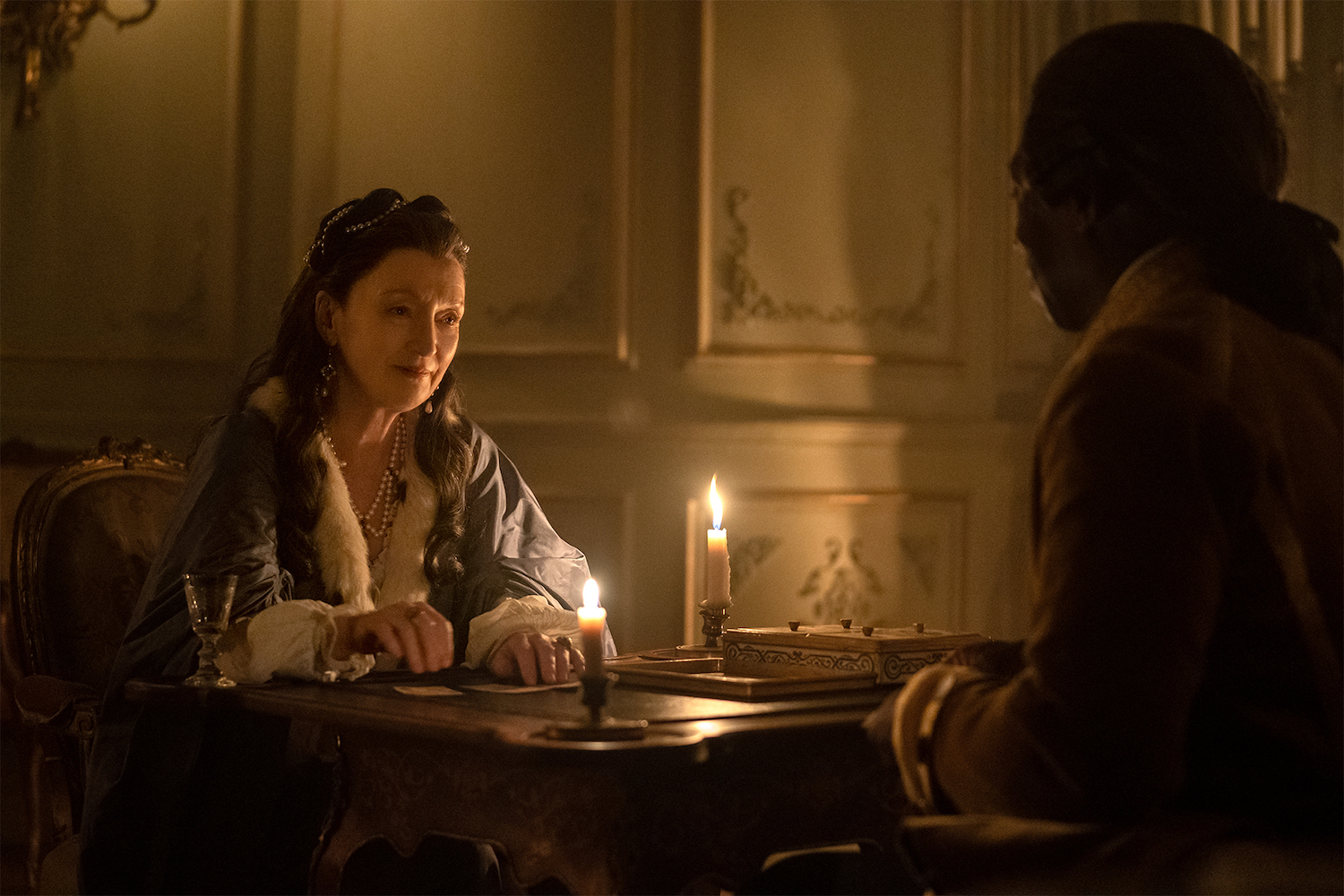 Genevieve (Lesley Manville) settles in for a quiet game of cards with Majordome (Hakeen Kae-Kazin).