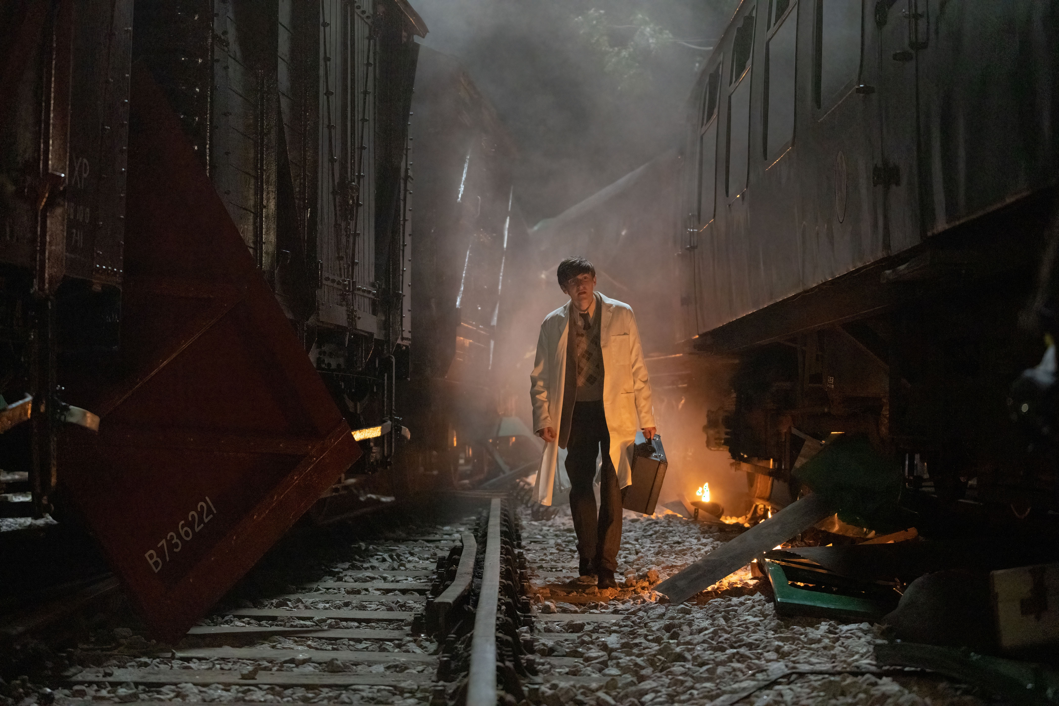 Picture shows: Tim Turner (Max Macmillan) wearing his Dr. Turner's white coat and carrying his medical bag goes in search of his father, past debris and fires from the train wreck. 