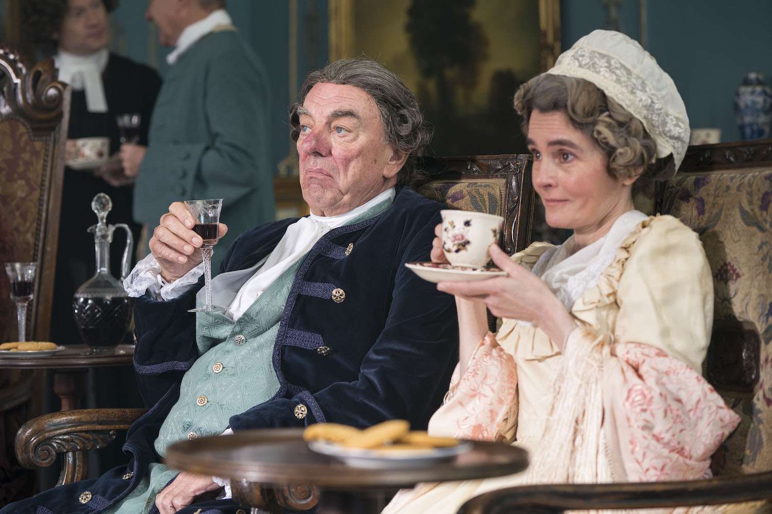 Picture shows: Aunt Western (Shirley Henderson) and Squire Western (Alun Armstrong) decide on Sophia's future. They are sitting on a sofa, wearing very fancy clothes, and drinking –– tea for Aunt Henderson and wine for the Squire.