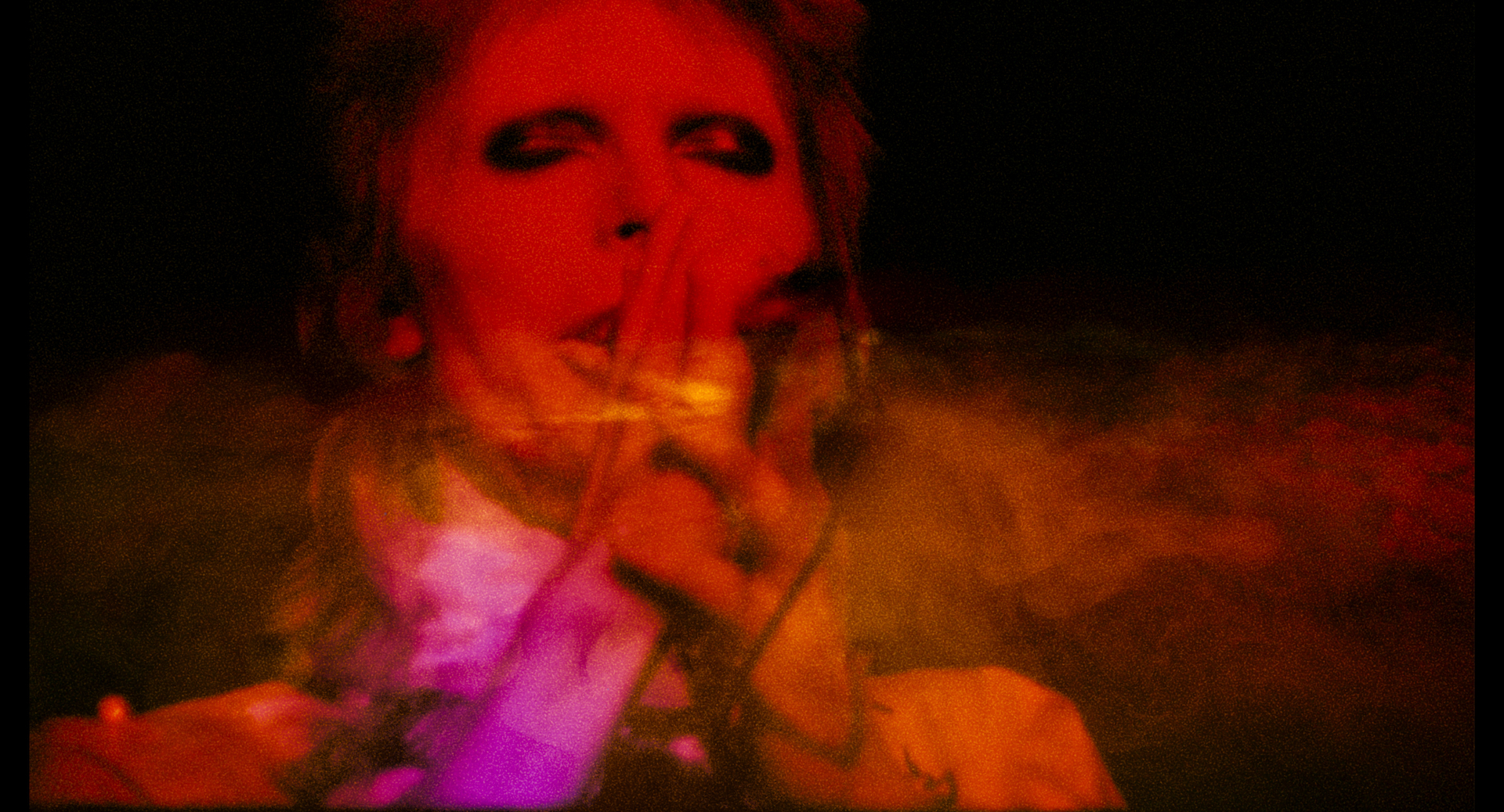 A smokey image of a young David Bowie crooning into the mic from 'Moonage Daydream'