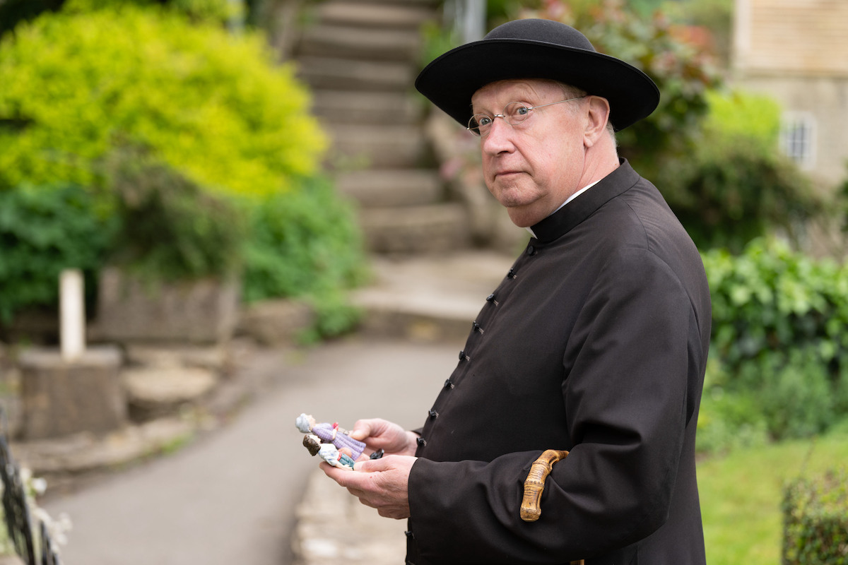 Mark Williams examines a clue as Father Brown in Season 10