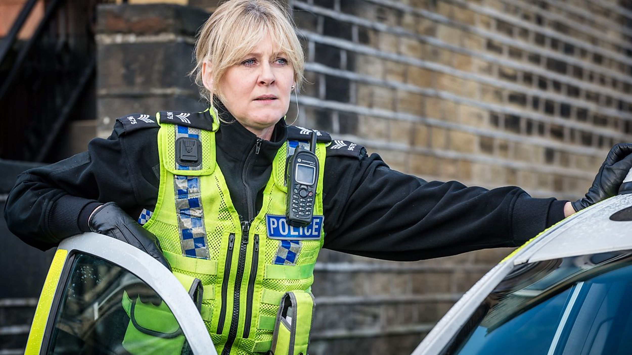 Sarah Lancashire as PC Catherine Cawood leans on her squad car in 'Happy Valley' series premiere