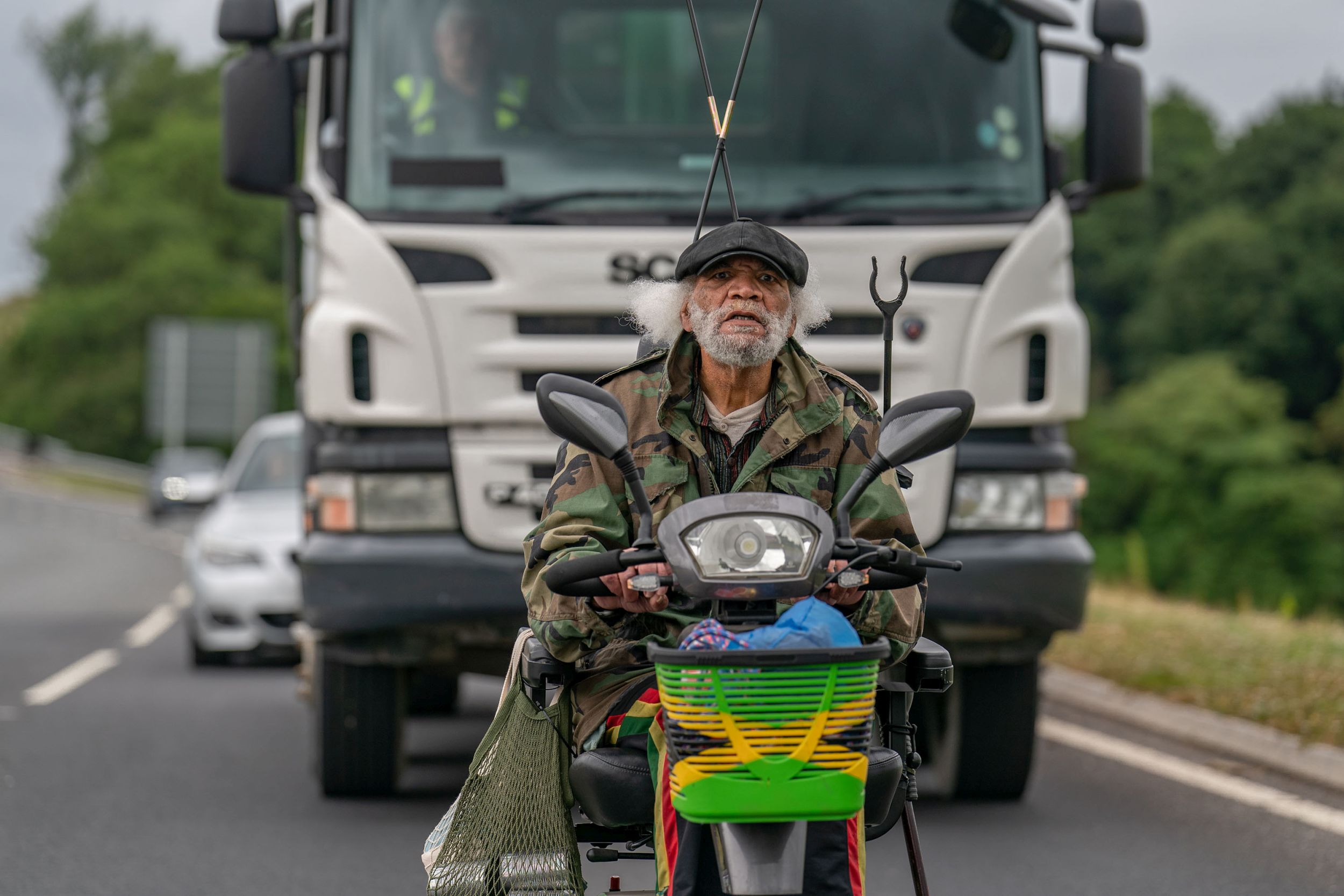 Paul Barber as Horse on a scooter in front of a lorry in The Full Monty