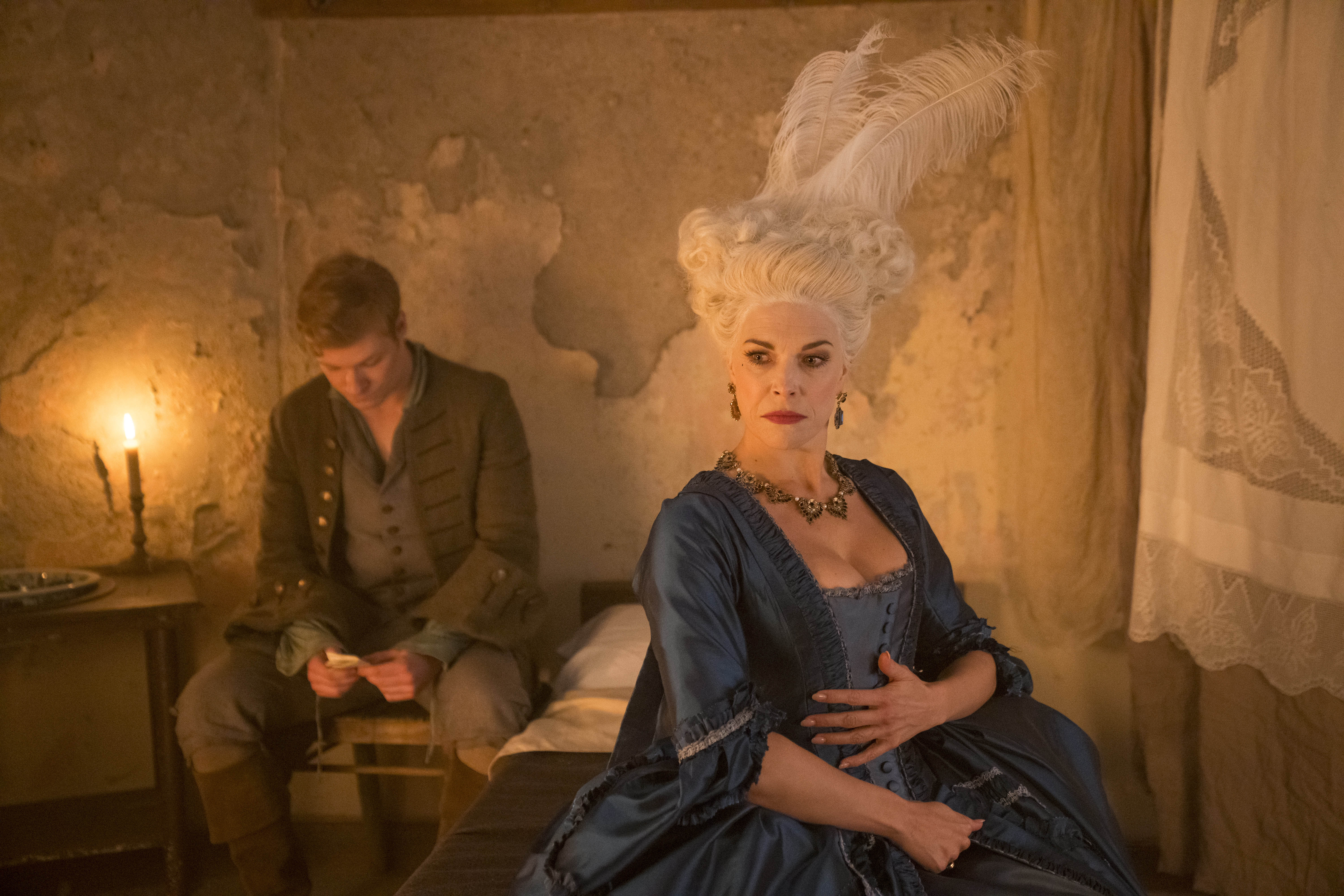 Picture shows: In Tom's humble room, Lady Bellaston (Hannah Waddingham) ponders what to do after Tom (Solly McLeod) announces their affair is over. He sits behind her on a chair, reading an unsent letter to Sophie. Lady Bellaston wears a lavish gown and a huge headdress of ostrich feathers. 