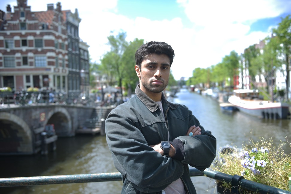 Picture shows: Eddie Suleman (Azan Ahmed) stands on a bridge over one of Amsterdam's famous canals.