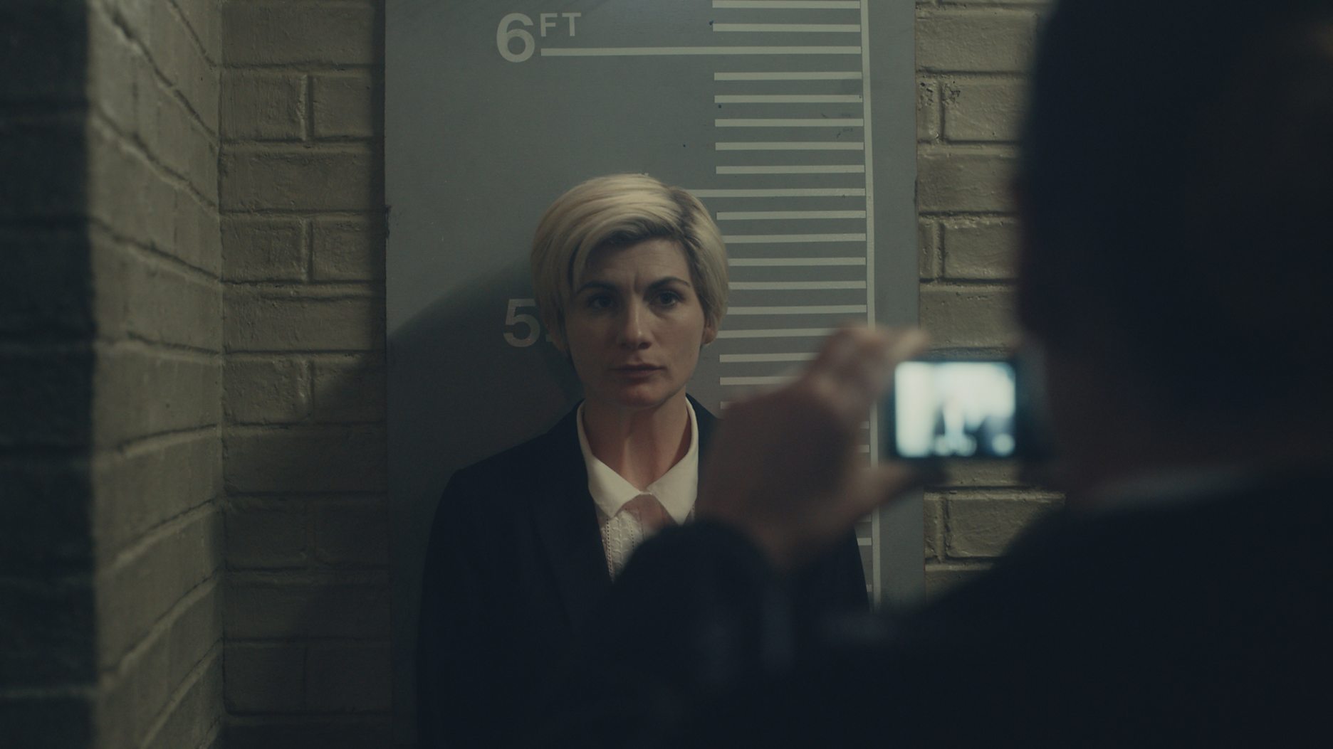 Jodie Whittaker as Orla getting her mugshot taken in 'Time' Season 2