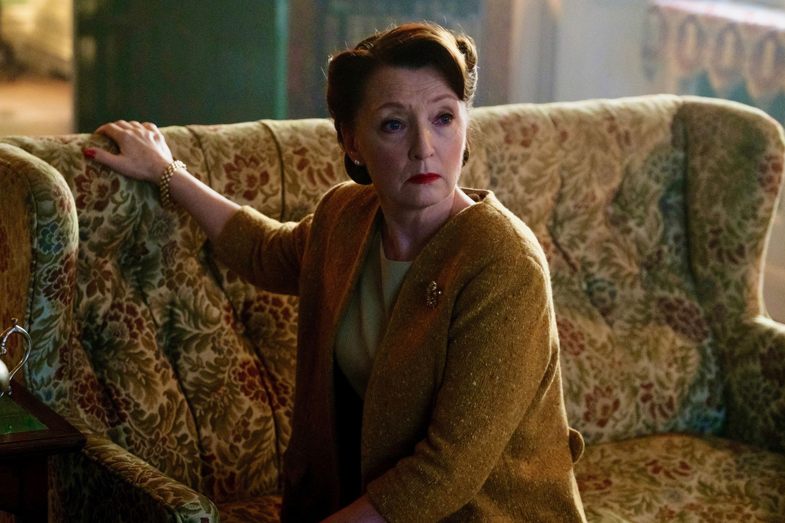 Lesley Manville as Roberta Chase sitting on the couch in 'World on Fire'