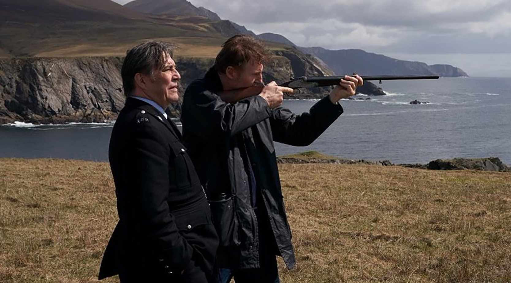 Ciarán Hinds as Vinnie and Liam Neeson as Finbar stand on a cliff in 'In the Land of Saints and Sinners'