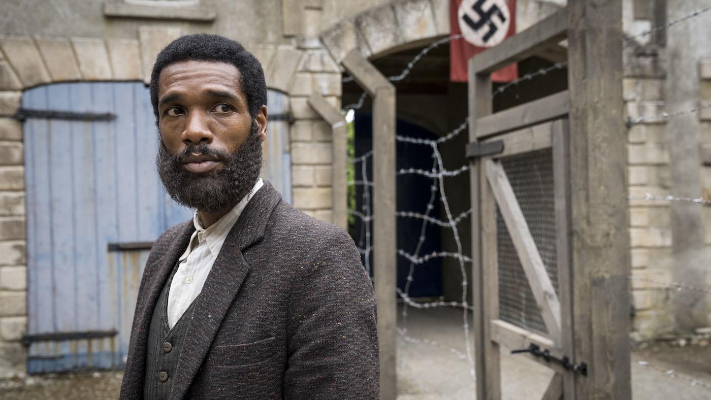 Picture shows: Albert (Parker Sawyers) in the Paris detention center. A swastika hangs behind him.