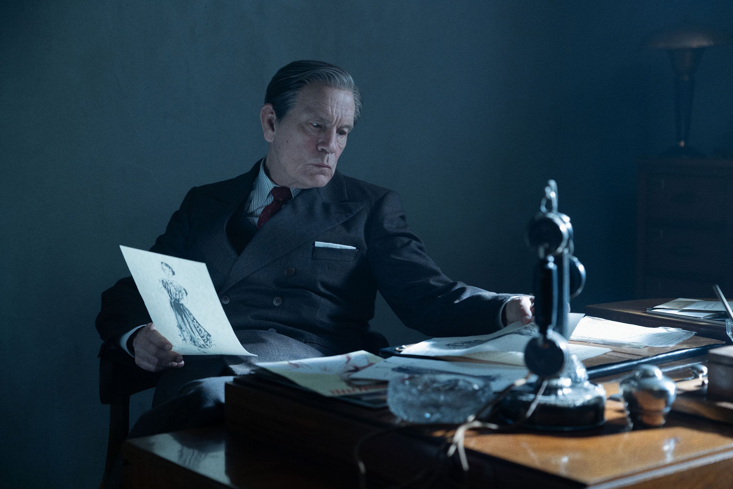 John Malkovich as Lucien Lelong at his desk in The New Look Season 1