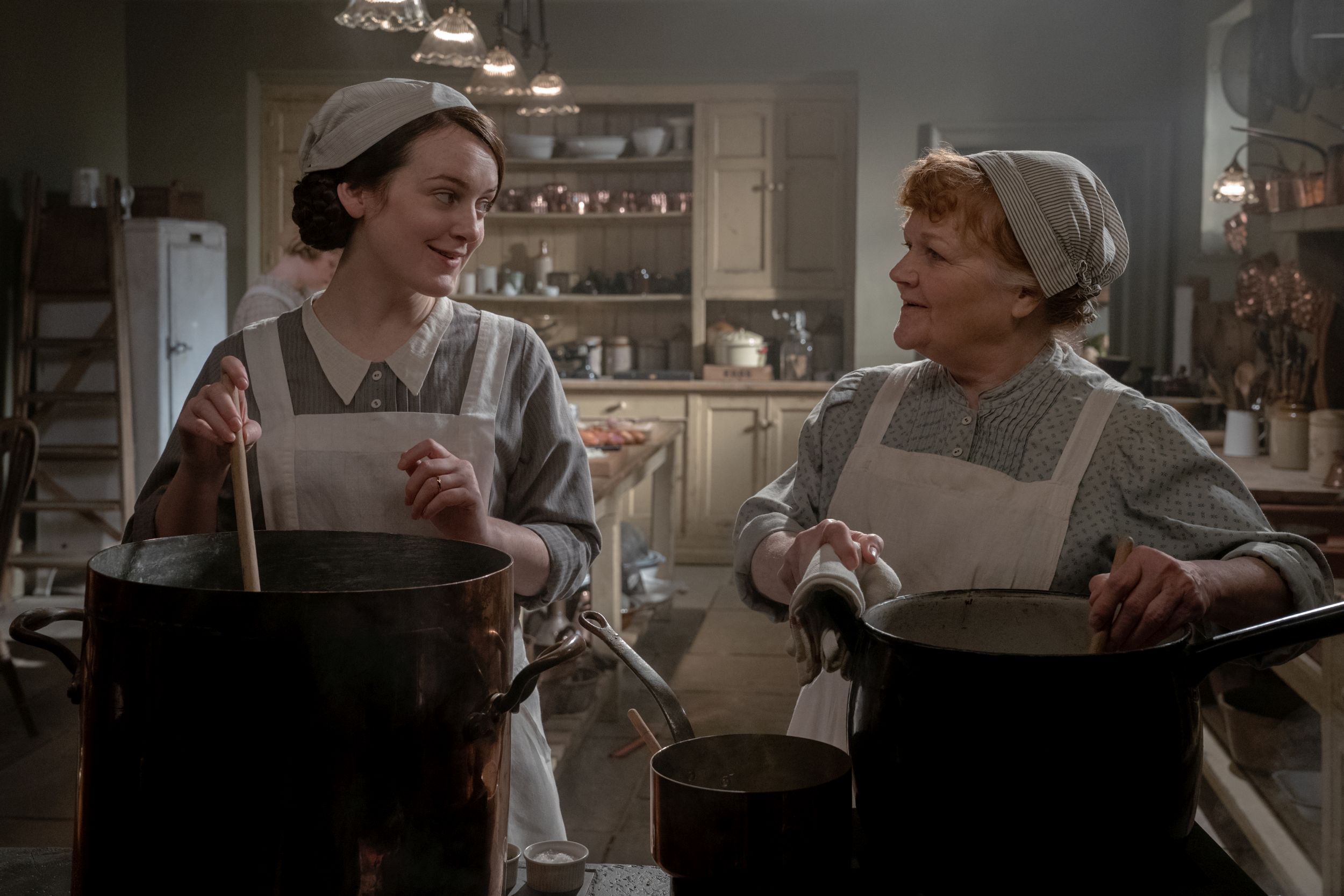 Sophie McShera stars as Daisy and Lesley Nicol stars as Mrs. Patmore in DOWNTON ABBEY: A New Era, a
