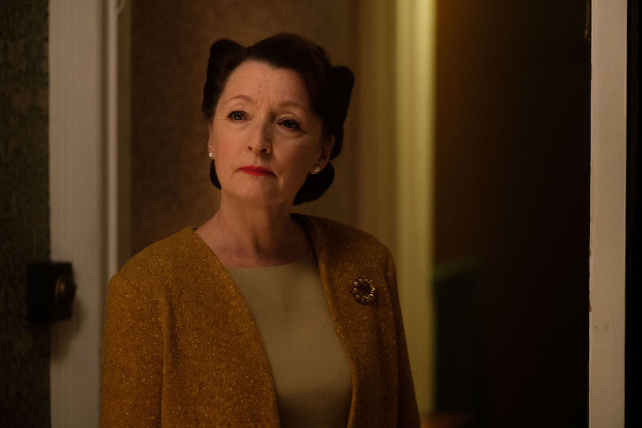 Lesley Manville as Robina Chase stands in a hallway in World on Fire Season 1