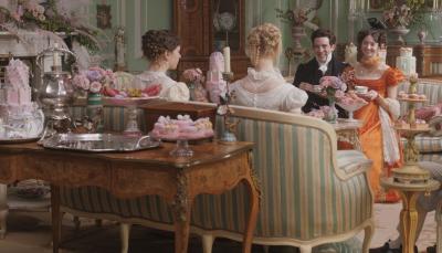 Picture shows: Harriet (Mia Goth) and Emma (Ana Taylor-Joy) host Mr. Elton (Josh O'Connor) and Mrs. Elton (Tanya Reynolds) at a tea party where there are many pastel-colored cakes and desserts.