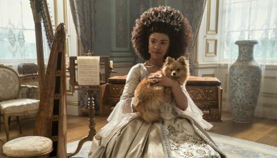 India Amarteifio as Young Queen Charlotte posing with her pup in 'Queen Charlotte: A Bridgerton Story.'