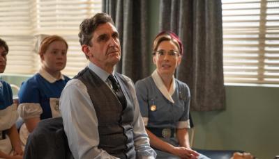 Picture shows: Nurse Shelagh Turner (Laura Main) and Dr Turner (Stephen McGann) sit in the front row at the lecture-demonstration of the ventouse. The device sits on a table in front of them.