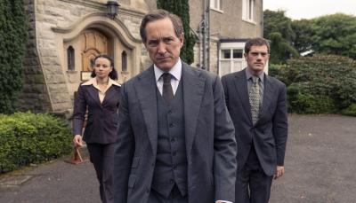 Picture shows: DCI Adam Dalgliesh (Bertie Carvel), flanked by DS Kate Miskin (Carlyss Peer) and DS Daniel Tarrant (Alistair Brammer) stand in front of an old stone building