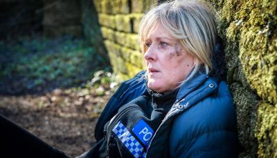 Sarah Lancashire as PC Catherine Cawood collapses against a wall in relief in 'Happy Valley' Season 1's finale