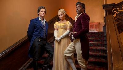 Jonathan Groff, Millie Gibson, and Ncuti Gatwa dressed in Regency era costumes standing on a staircase