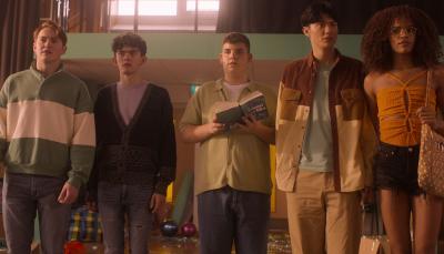 Kit Conner as Nick, Joe Locke as Charlie, Tobie Donovan as Isaac, William Gao as Tao, and Yasmin Finney as Elle stand in a messy school gym in 'Heartstopper' Season 2