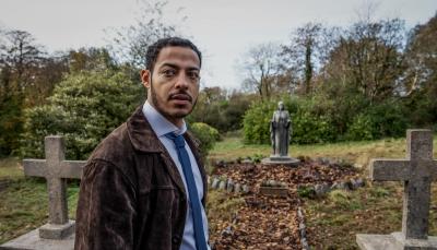Daryl McCormack as Detective Colman Akande hangs out in graveyards in 'The Woman in the Wall'