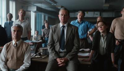 Hugh Bonneville as DCI Boyce and Charlotte Spencer as DS Jennings watch a lecture in 'The Gold' Episode 2.