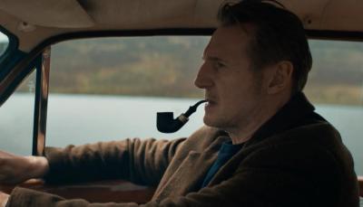 Liam Neeson as Finbar driving, pipe in mouth, in In the Land of Saints and Sinners