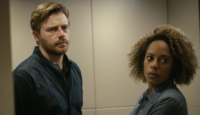 Jack Lowden as River Cartwright and Rosalind Eleazar as Louisa Guy are interrupted in the hall in Slow Horses Season 3