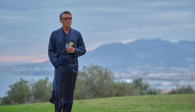 Jason Isaacs as Cary Grant, holding a gin and tonic in his Los Angeles home in 'Archie'