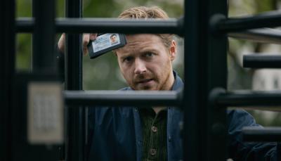 Jack Lowden as River Cartwright frustratedly showing his ID through a gate in 'Slow Horses' Season 3