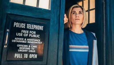 Jodie Whittaker as the 13th Doctor stands in the doorway of the TARDIS