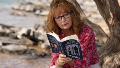 Lesley Manville as Susan Ryeland reading the new Alan Conway novel in 'Moonflower Murders'