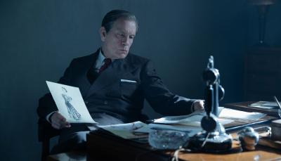 John Malkovich as Lucien Lelong at his desk in The New Look Season 1