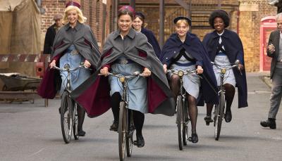 Helen George as Trixie Franklin, Megan Cusak as Nancy Corrigan, Natalie Quarry as Rosalind Clifford, and Renee Bailey as Joyce Highland ride their bicycles out into the street tl make their rounds in 'Call the Midwife' Season 13