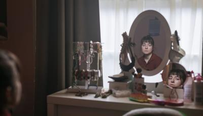 Hazel Doupe as Harper Fenn looks at herself in her vanity mirror in 'Sanctuary: A Witch's Tale' Season 1