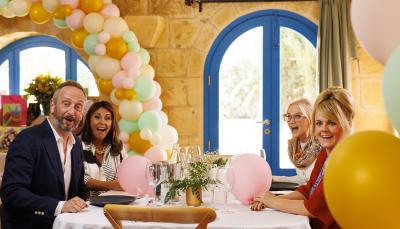 Steve Edge as Dom Hayes, Roma Malik as Jane, Elaine O'Dwyer as Marie, and Sally Lindsay as Jean White sitting at the party table in The Madame Blanc Mysteries Season 3