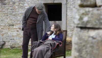 Picture shows: Richard Alderson (Tony Pitts) fusses over his pregnant daughter Helen Herriot (Rachel Shenton). She's sitting in a chair in a sunny farmyard wrapped in a blanket.