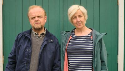 Toby Jones as Alan Bates, Julie Hesmondhalgh as Suzanne Sercombe stand in front of their house in 'Mr Bates vs the Post Office'