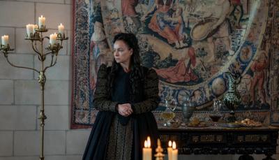 Catherine de Medici (Samantha Morton) poses by candlelight in front of a tapestry