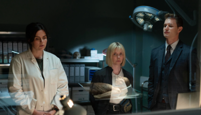 Picture shows: River Wilde (Emer Kenny), Karen Pirie (Lauren Lyle) and DC Jason "Mint" Murray (Chris Jenks) behind a glass wall.
