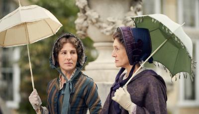 Tamsin Grieg as Anne Trenchard and Harriet Walter as Caroline Bellasis walking with parasols in 'Belgravia' Season 1