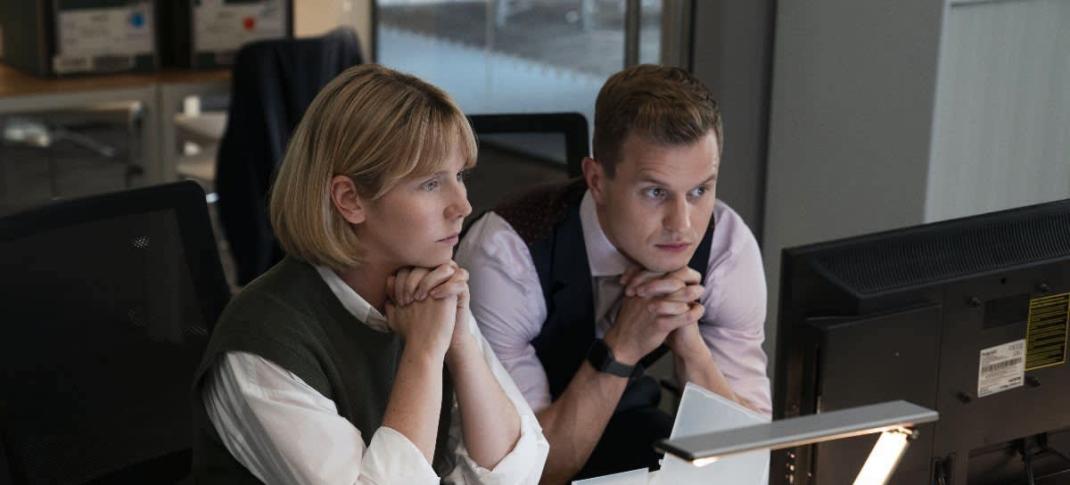 Picture shows: Karen Pirie (Lauren Lyle) and Jason "The Mint" Murray (Chris Jenks) sit side by side behind a desk looking at a computer screen