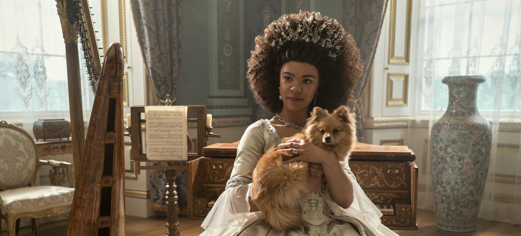 India Amarteifio as Young Queen Charlotte posing with her pup in 'Queen Charlotte: A Bridgerton Story.'