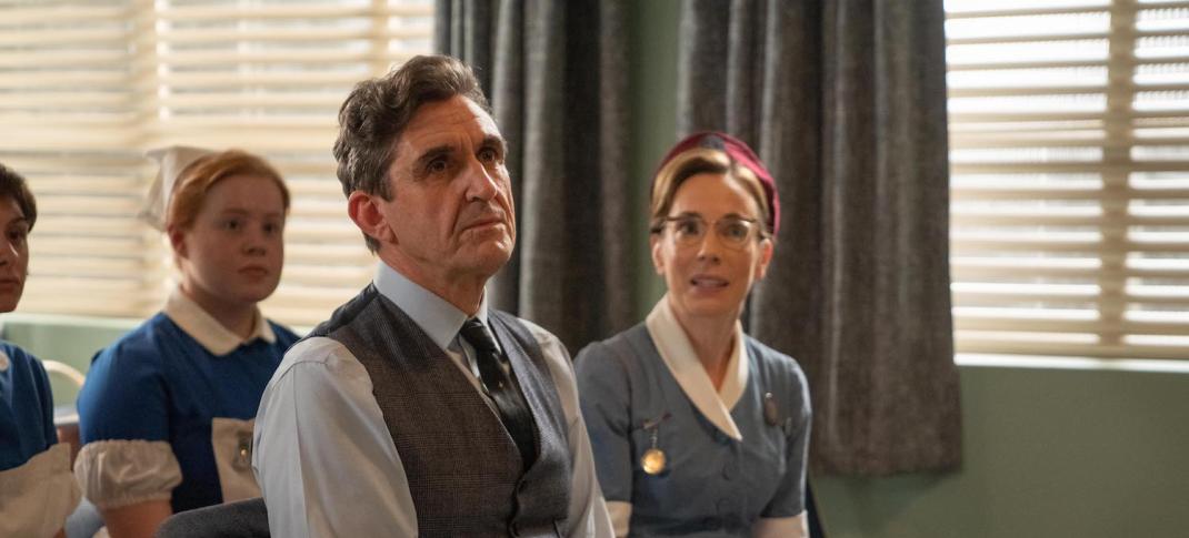 Picture shows: Nurse Shelagh Turner (Laura Main) and Dr Turner (Stephen McGann) sit in the front row at the lecture-demonstration of the ventouse. The device sits on a table in front of them.