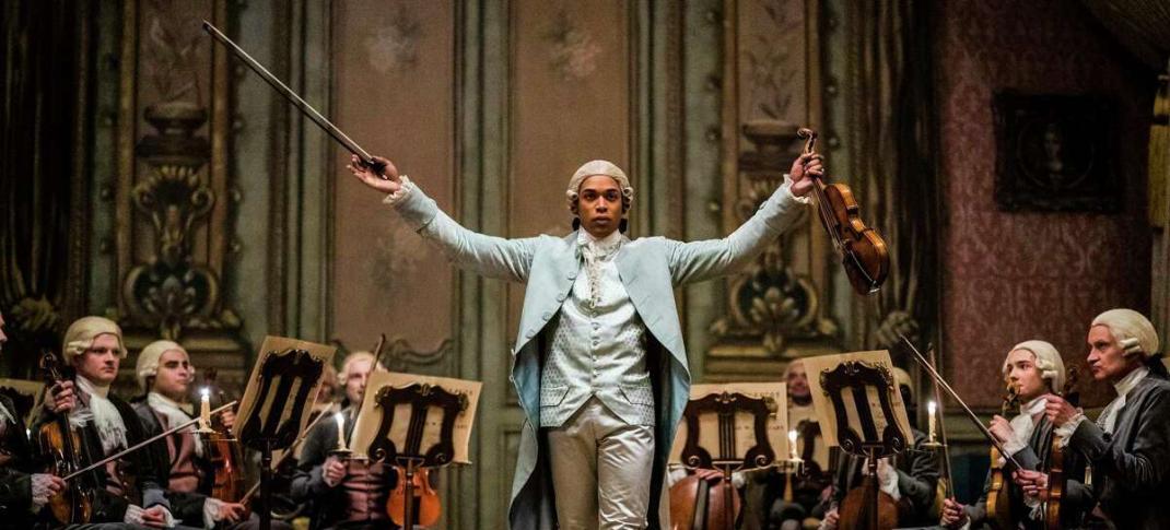 Picture shows: Chevalier (Kelvin Harrison Jr.) holds his violin and bow in front of an orchestra.