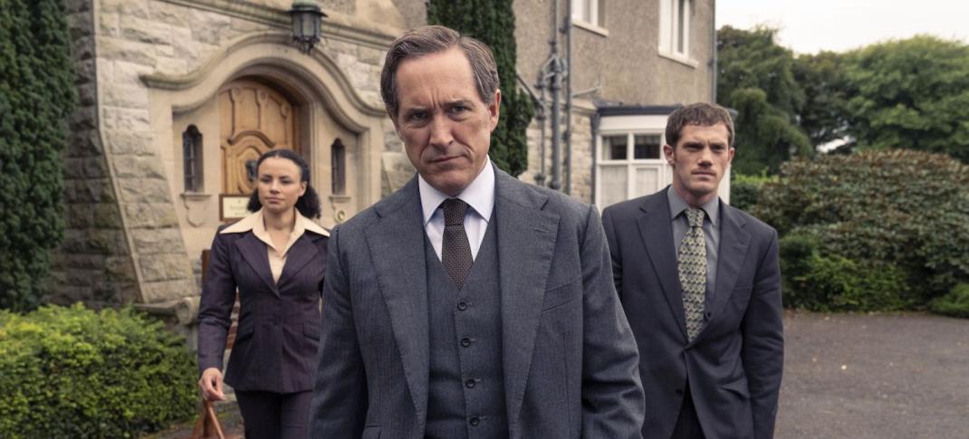 Picture shows: DCI Adam Dalgliesh (Bertie Carvel), flanked by DS Kate Miskin (Carlyss Peer) and DS Daniel Tarrant (Alistair Brammer) stand in front of an old stone building