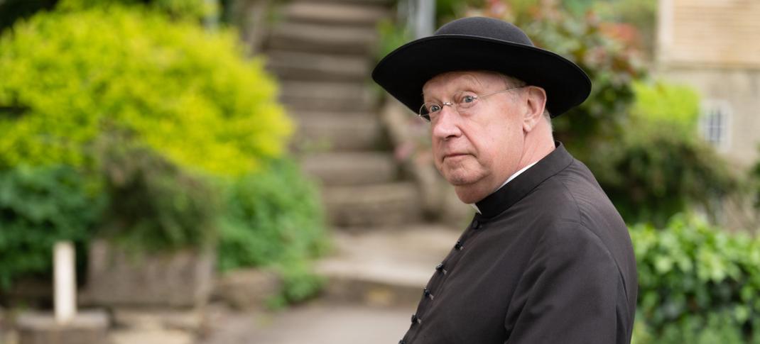 Mark Williams examines a clue as Father Brown in Season 10