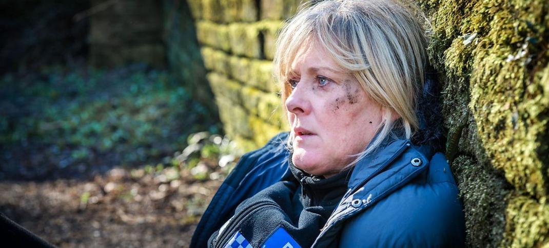 Sarah Lancashire as PC Catherine Cawood collapses against a wall in relief in 'Happy Valley' Season 1's finale