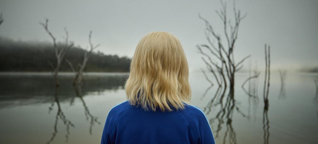 Julia Savage as Amy stares at a lake in Hulu's The Clearing