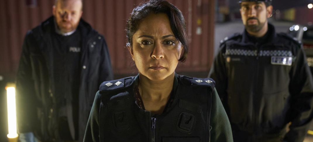 DI Ray in her police uniform looking serious with two officers standing behind her.